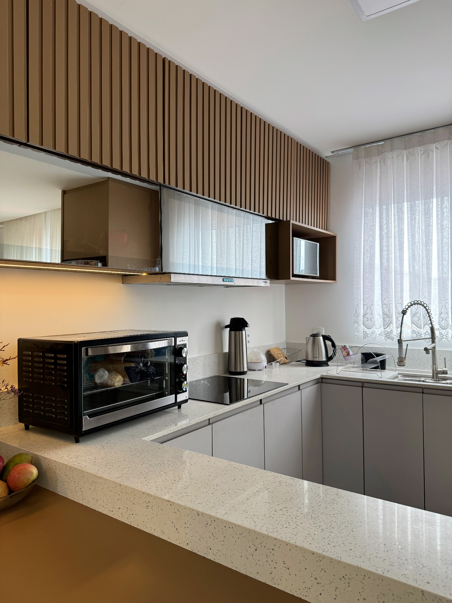Cozinha planejada com painel ripado e bancada em quartzo